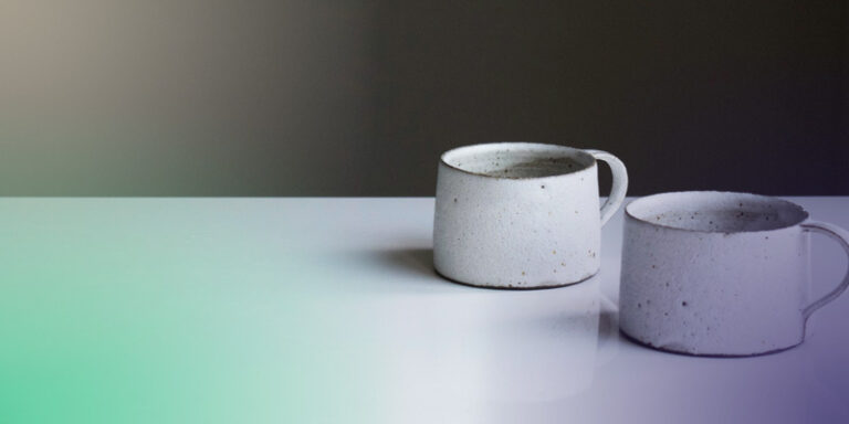 Two cups of coffee on a table symbolizing a business partner buyout situation.