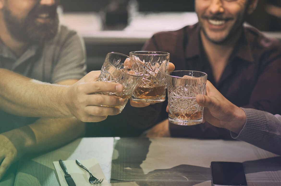 People toasting their whiskey glasses at a local craft distillery