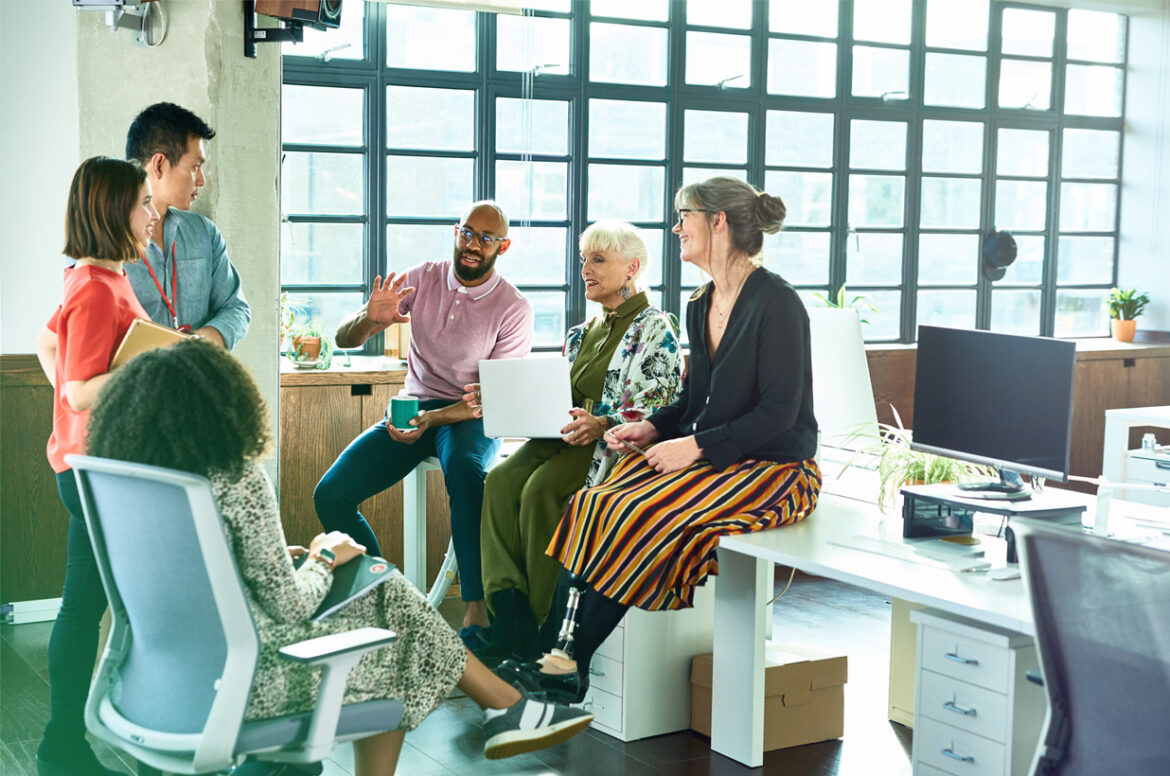 A group of company employees at work discussing the new employee stock ownership plan (ESOP)
