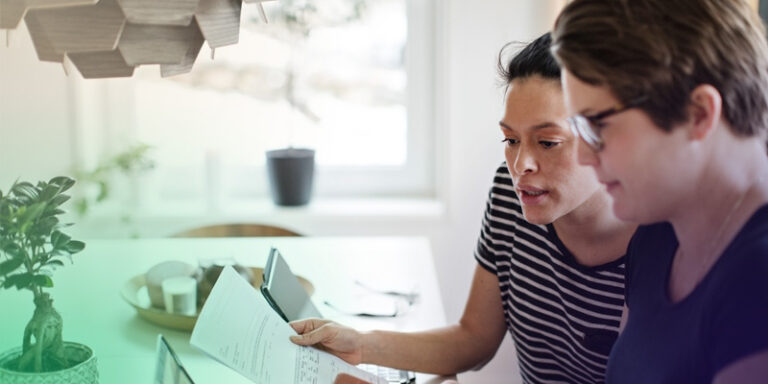 Two females looking at paperwork on how to maximize their FDIC insurance.