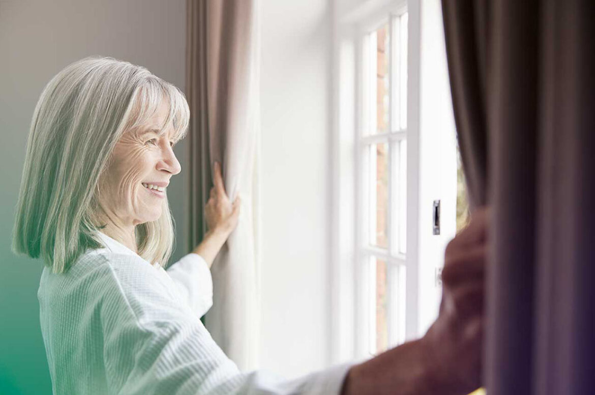 Senior care tenant smiling and looking out the window