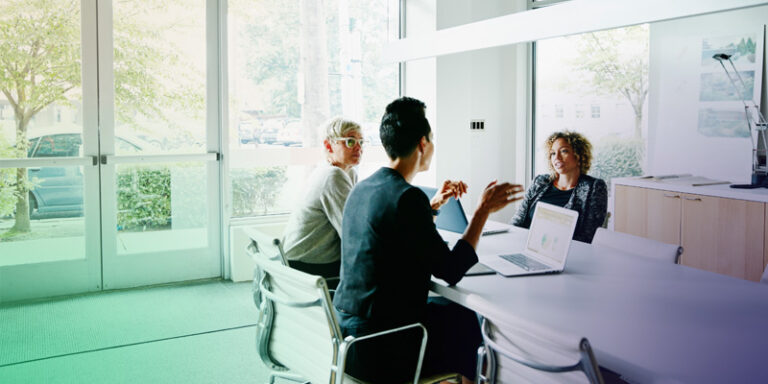 Female business owners sitting together at a table discussing how to close an sba loan faster.