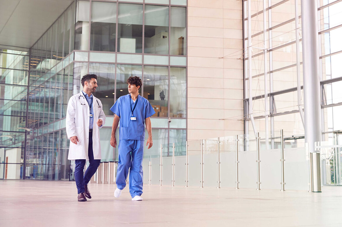 Two medical professionals walking & talking at a healthcare commercial real estate facility