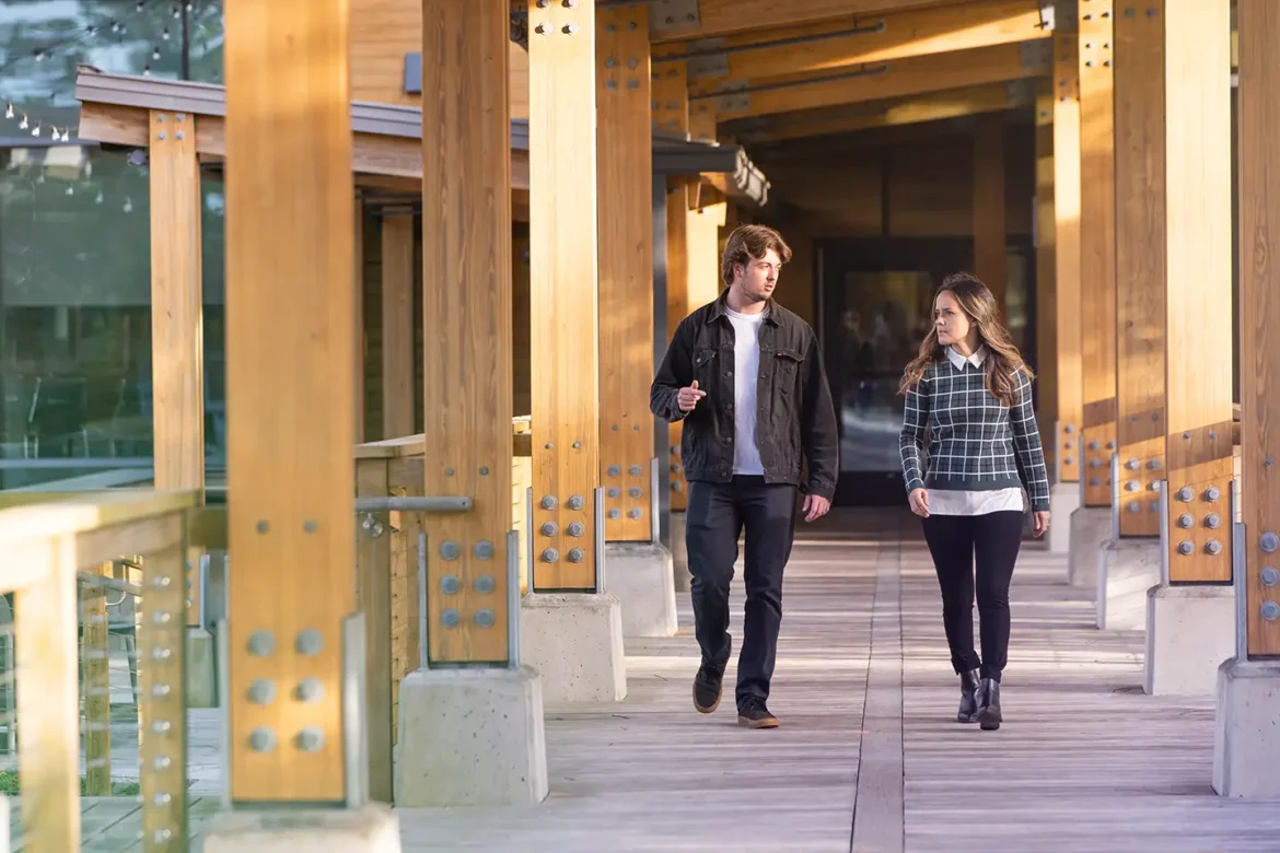 A male and female employee walking the campus at Live Oak Bank discuss life at the bank, workplace culture and their comprehensive benefits