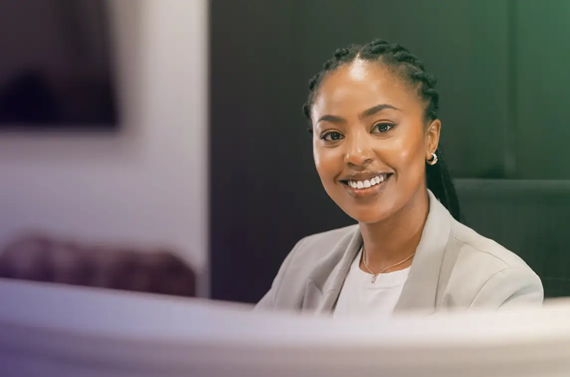 A business woman smiling while sitting at a desk